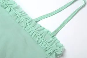 Close-up detail of the mint green ruffled mesh trim and delicate thin strap on a dress