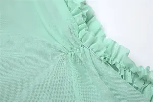 Detailed macro shot of mint green pleated mesh ruffles on an elegant camisole dress.