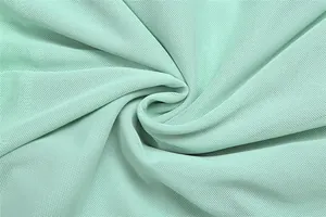 Macro detail of breathable mint green mesh fabric texture for elegant evening dress