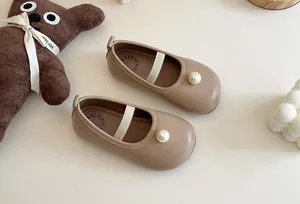 Detailed view of elegant beige girl's Mary Jane shoes with pearl accent and soft leather