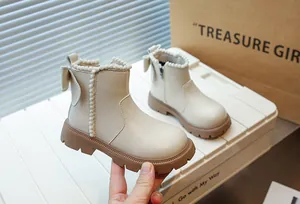 Gros plan de bottines pour filles avec un joli nœud et une bordure à pompons