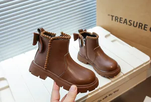 Gros plan de bottines Martin marron pour fille avec doublure en peluche et nœud chic