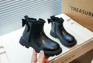 Vue détaillée de bottines noires pour filles avec nœud arrière et bordure à pompons