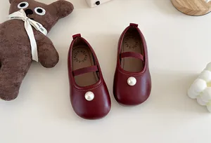 Detailed view of elegant deep red girls' Mary Jane leather shoes with pearl decor