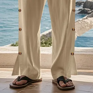 Détail du pantalon en lin beige pour homme avec boutons latéraux et fente.