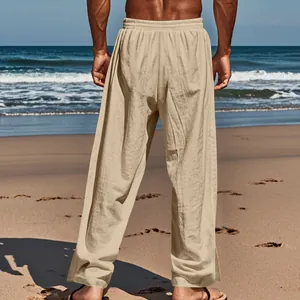 Vue arrière d'un pantalon en lin beige pour homme sur une plage, coupe ample décontractée.
