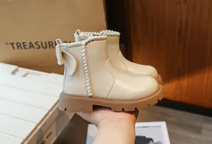 Vue latérale détaillée de bottines beiges pour filles avec pompons et nœud