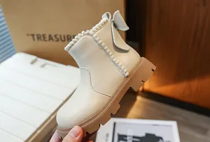 Vue détaillée des bottines Martin beiges pour fille avec un nœud et une bordure peluche.