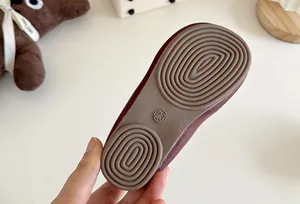 Close-up of anti-slip rubber sole on girls' burgundy Mary Jane leather shoes