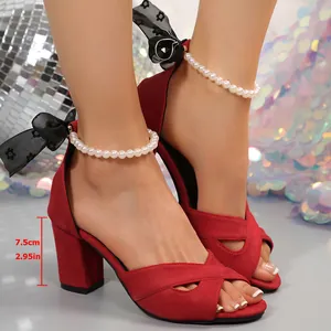 Vue détaillée de sandales rouges en daim à talons épais avec perles et nœuds en dentelle.