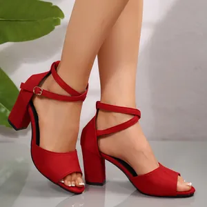 Vue latérale de sandales élégantes en daim rouge avec talon bloc de 7cm et bride cheville
