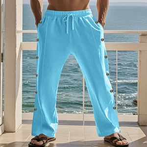 Détail du pantalon en lin bleu clair avec taille à cordon et des boutons latéraux.