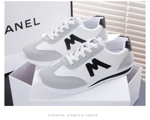 Detailansicht von grauen und weißen Damen-Sneakern auf einem minimalistischen Karton