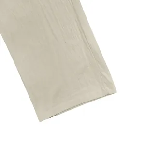 Macro view showing the breathable beige linen fabric texture and hem of men's casual pants