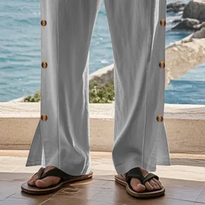 Détail du pantalon en lin pour hommes avec boutons latéraux et ourlet fendu.