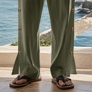 Détail de ce pantalon en lin vert olive avec boutons latéraux et fente aux jambes