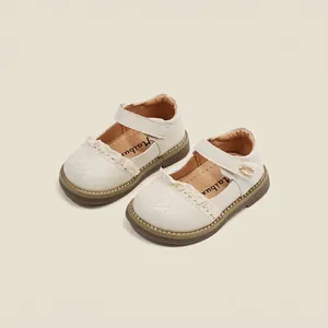 Close-up of cream colored toddler girl Mary Jane shoes with lace and floral embroidery