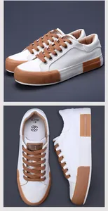 Detailed view of men's white canvas low-top sneakers with brown laces and patches