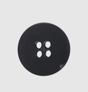 Détail d'un bouton noir mat à quatre trous en nylon recyclé pour vêtements de luxe