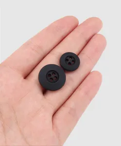 Vue détaillée de boutons noirs mats en nylon recyclé fabriqués à partir de filets de pêche