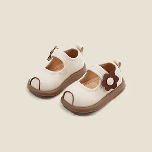 Detail shot of toddler girl's cream Mary Jane shoes with brown flower and anti-collision toe