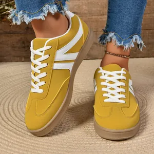 Detailed view of women's yellow retro round toe lace-up sneakers with stylish white stripes