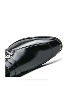 Close-up macro detail of black glossy leather dress shoe featuring a silver metal buckle
