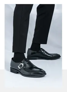 Men's sleek black business casual leather shoes with silver buckle detail on feet.
