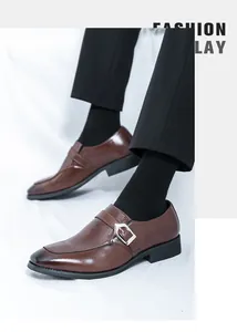 Detailed view of brown leather monk-strap business casual shoes worn with black socks.