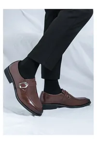 Detailed side view of brown leather monk strap dress shoes worn with professional trousers