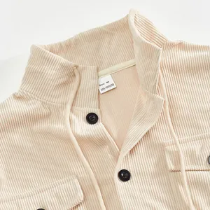 Close-up of beige corduroy jacket collar showing texture and polyester size label.