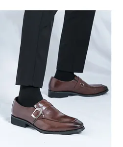 Close-up view of elegant men's brown leather monk strap shoes featuring a silver metal buckle