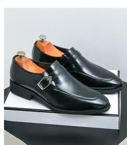 Detailed view of black leather monk strap dress shoes with silver buckle