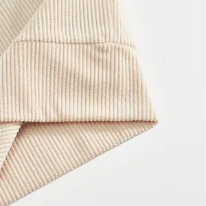 Detailed macro view of beige corduroy fabric texture and stitching on men's jacket