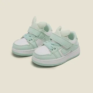 Detalle de cerca de zapatillas para niños verde menta con diseño de orejas de conejo.