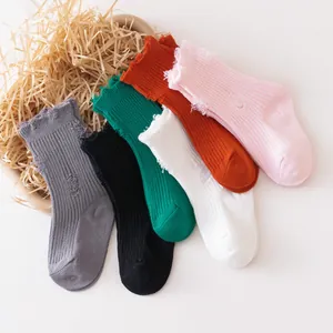 Close-up detail of distressed ribbed socks for kids in multiple vibrant colors