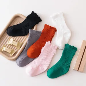 Close-up of trendy distressed mid-calf children's socks in various solid colors
