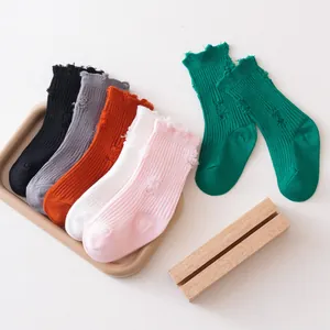 Close-up detail of distressed solid color children's socks in various vibrant fashion shades