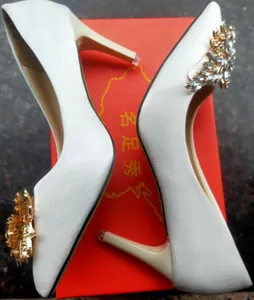 Détail d'escarpins de mariage en satin blanc avec décoration en strass brillant