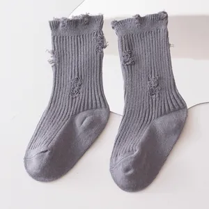 Detail view of grey ribbed distressed socks for children with ruffled tops