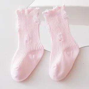 Detailed view of pink ripped distressed mid-tube kids socks with ruffled frayed cuffs