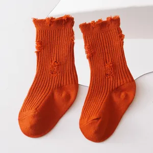 Close-up showing texture of orange distressed mid-calf beggar style socks for kids