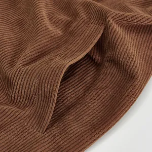 Close-up of brown corduroy fabric texture and pocket on a vintage workwear jacket
