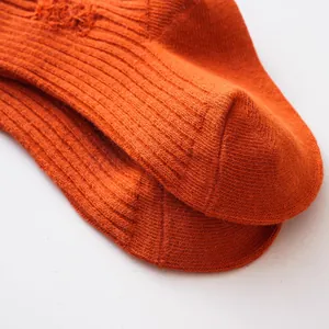 Detail of orange ribbed distressed children's socks showing fine knit texture