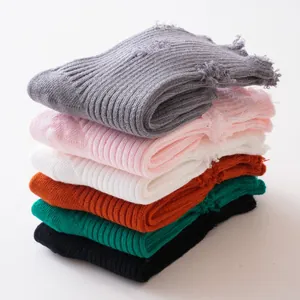 Detailed view of stacked solid color distressed children's socks in multiple colors