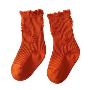 Stylish orange distressed children's crew socks with a double needle knit texture design.