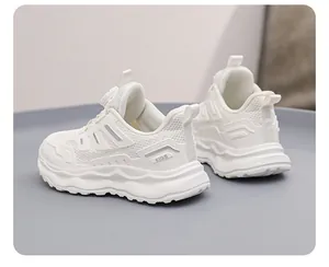 Detail view of breathable white mesh running sneakers for kids featuring chunky soles.
