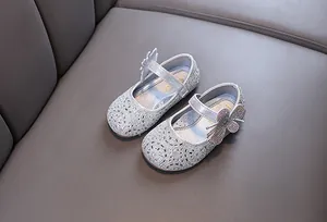 Close-up of sparkling silver girl's princess shoes with rhinestone butterfly detail