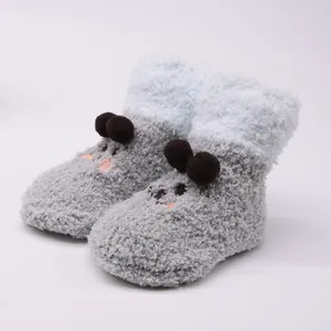 Detailed view of grey fuzzy baby booties with cute cartoon ears and soft plush texture