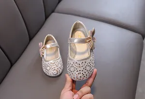 Close-up detail of champagne rhinestone Mary Jane princess shoes featuring a glittery bow